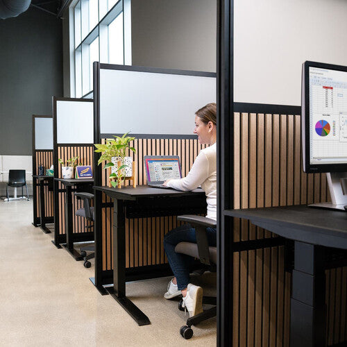 Person working at a desk with a wooden screen in an office setting