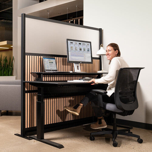 Person sitting at a desk with a screen and chair in an office setting
